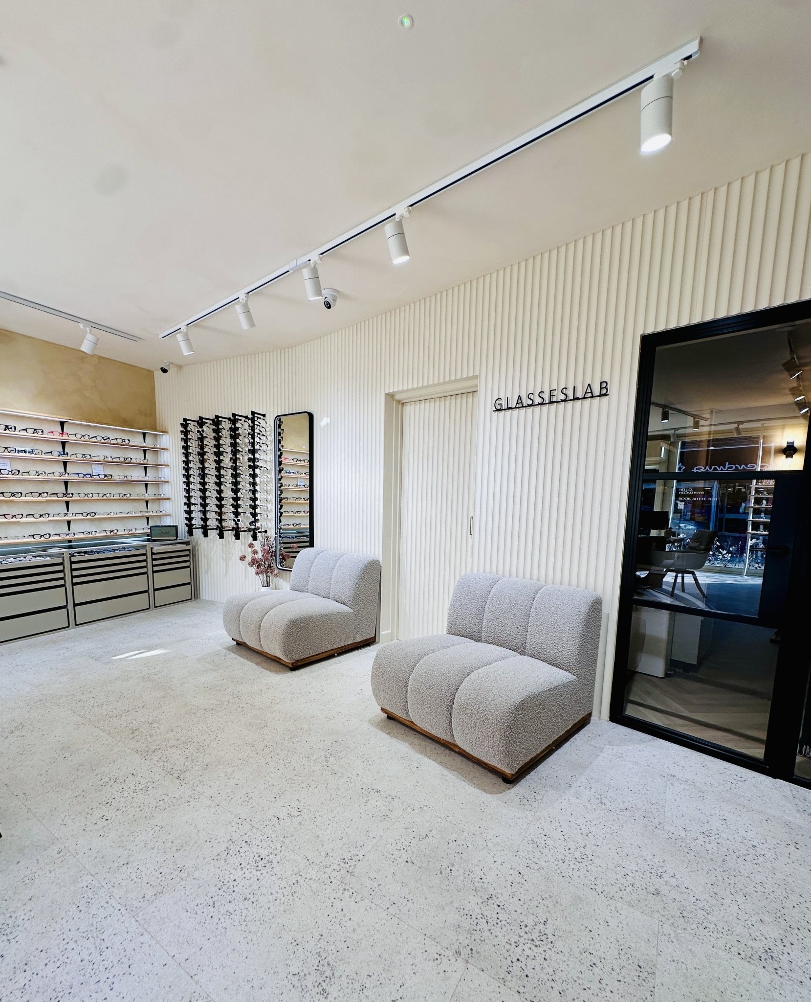 Interior of Glasseslab Beckenham opticians featuring eyewear displays, seating and modern store design
