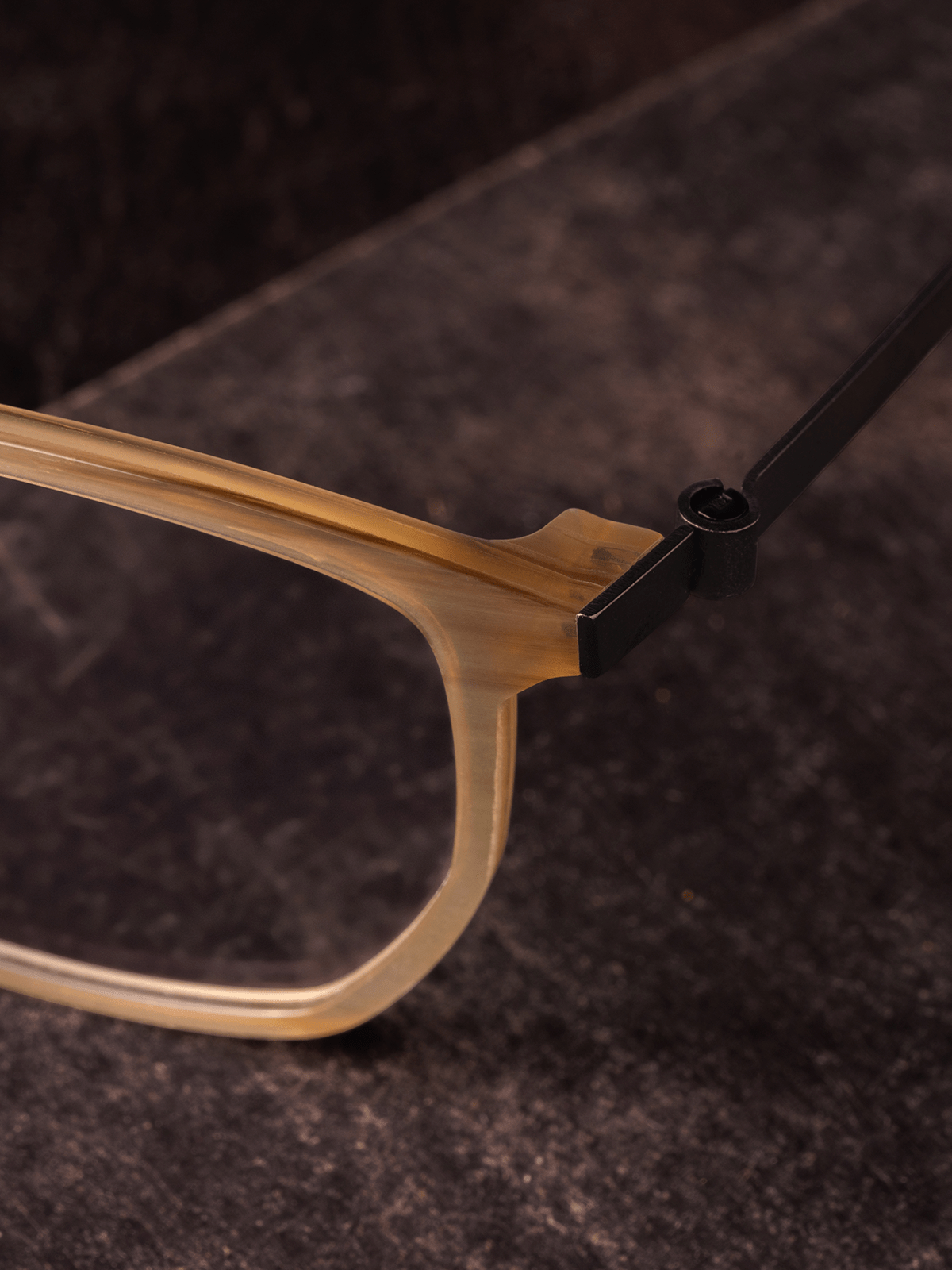 Close-up of a LINDBERG eyewear frame showing the titanium hinge and acetate front in detailed studio lighting